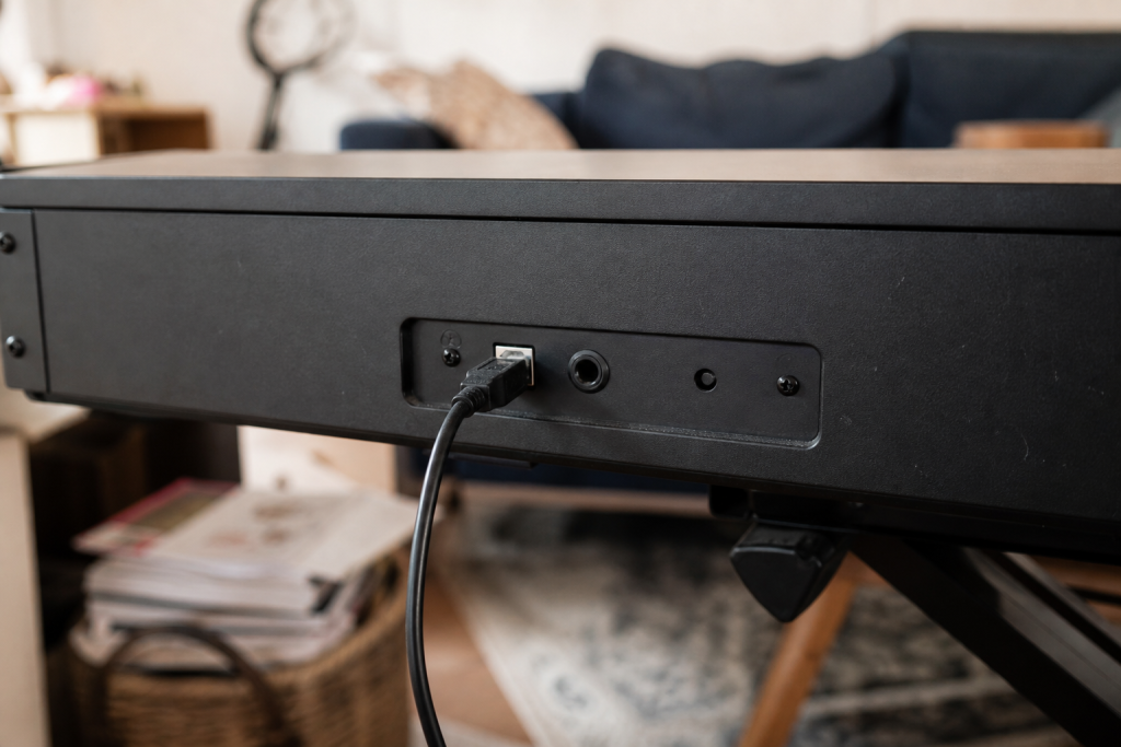 Connectique arrière d'un piano numérique avec câble USB branché