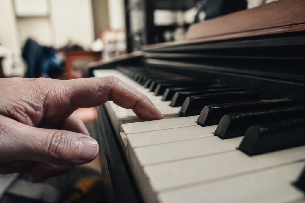 Doigt appuyant sur la touche d'un piano numérique à toucher lourd